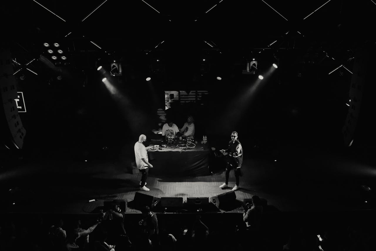 Black and white aerial shot of musicians performing live on stage.